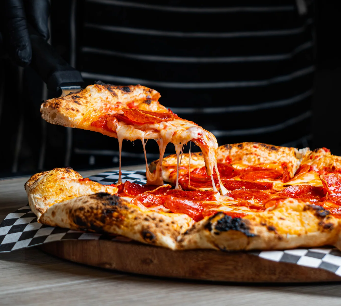 A slice lifted from a freshly baked artisan pizza